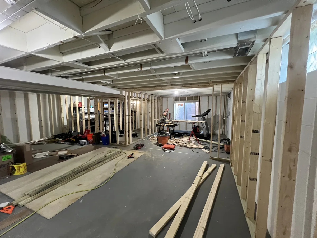 Unfinished basement framed out with new studs and an open subfloor