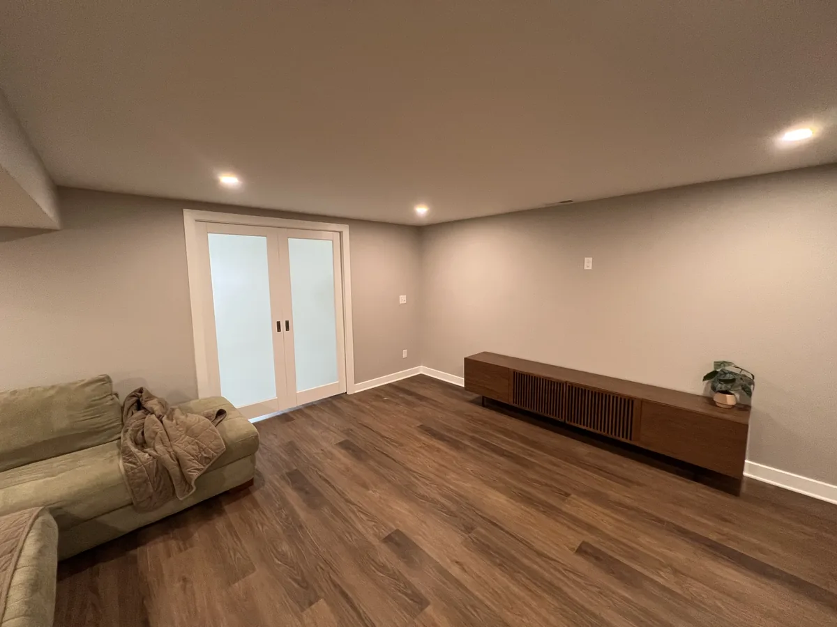 Finished basement room with french doors and fresh painted walls