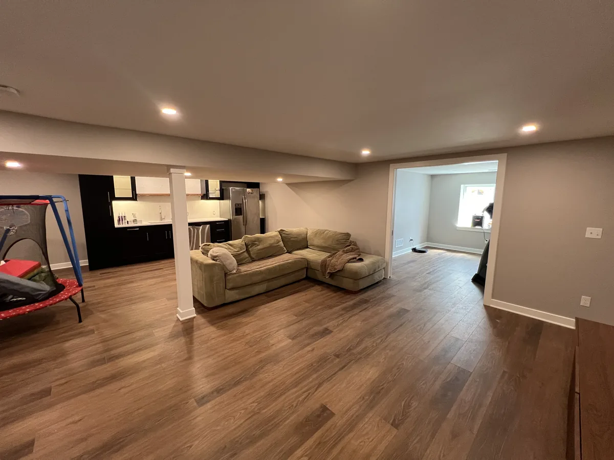 Finished basement with a seating area opening onto a built in bar