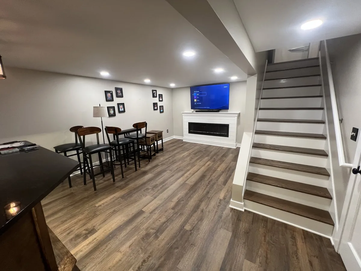 Finished basement living and dining area with a new staircase and recessed lighting