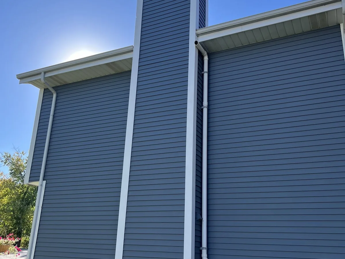 Blue lap siding installed on a two story wall and chimney chase