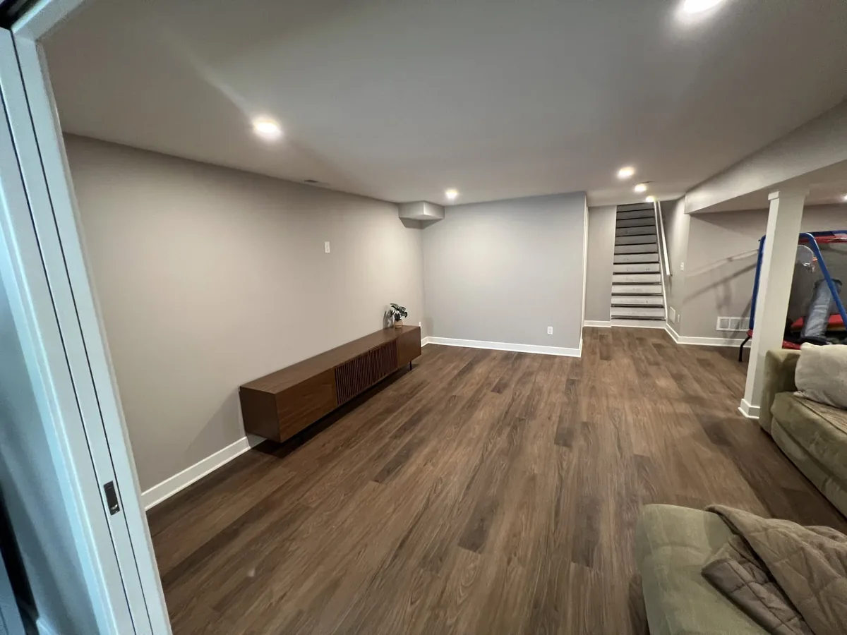 Finished basement room with wide plank flooring and fresh painted walls