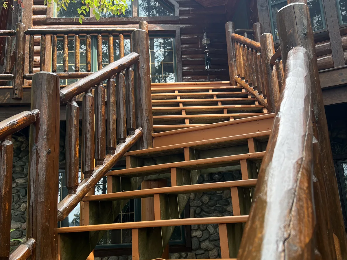 Log home deck and stair railings under construction with fresh cut timbers
