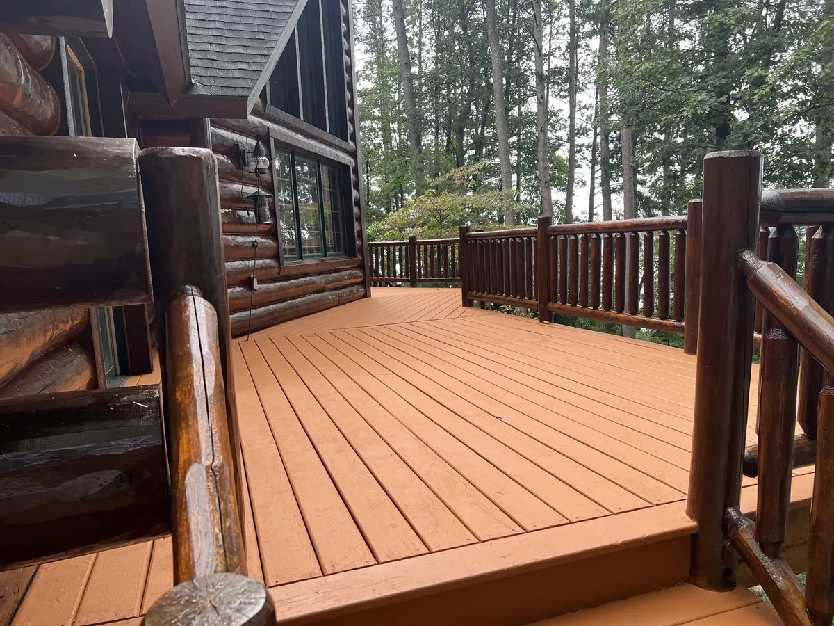 Rebuilt deck on a log home with cedar stained boards and log railings