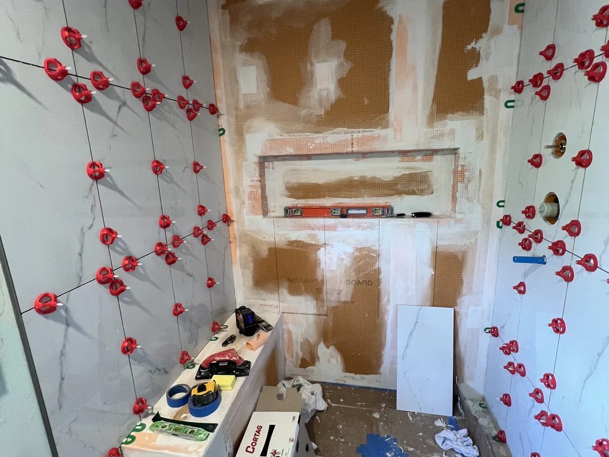 Shower walls sealed with waterproofing coating around a recessed niche