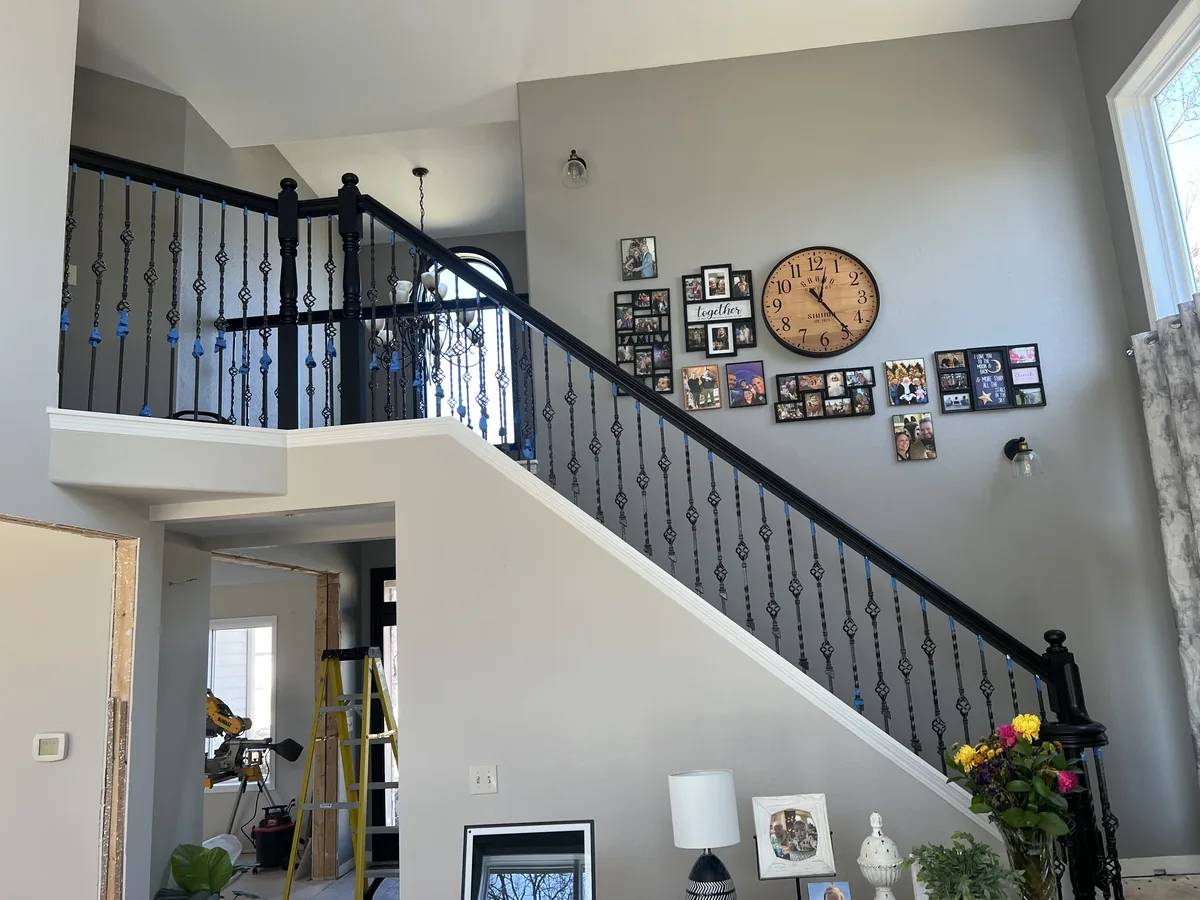 Open living area with a new black railed staircase and second floor landing
