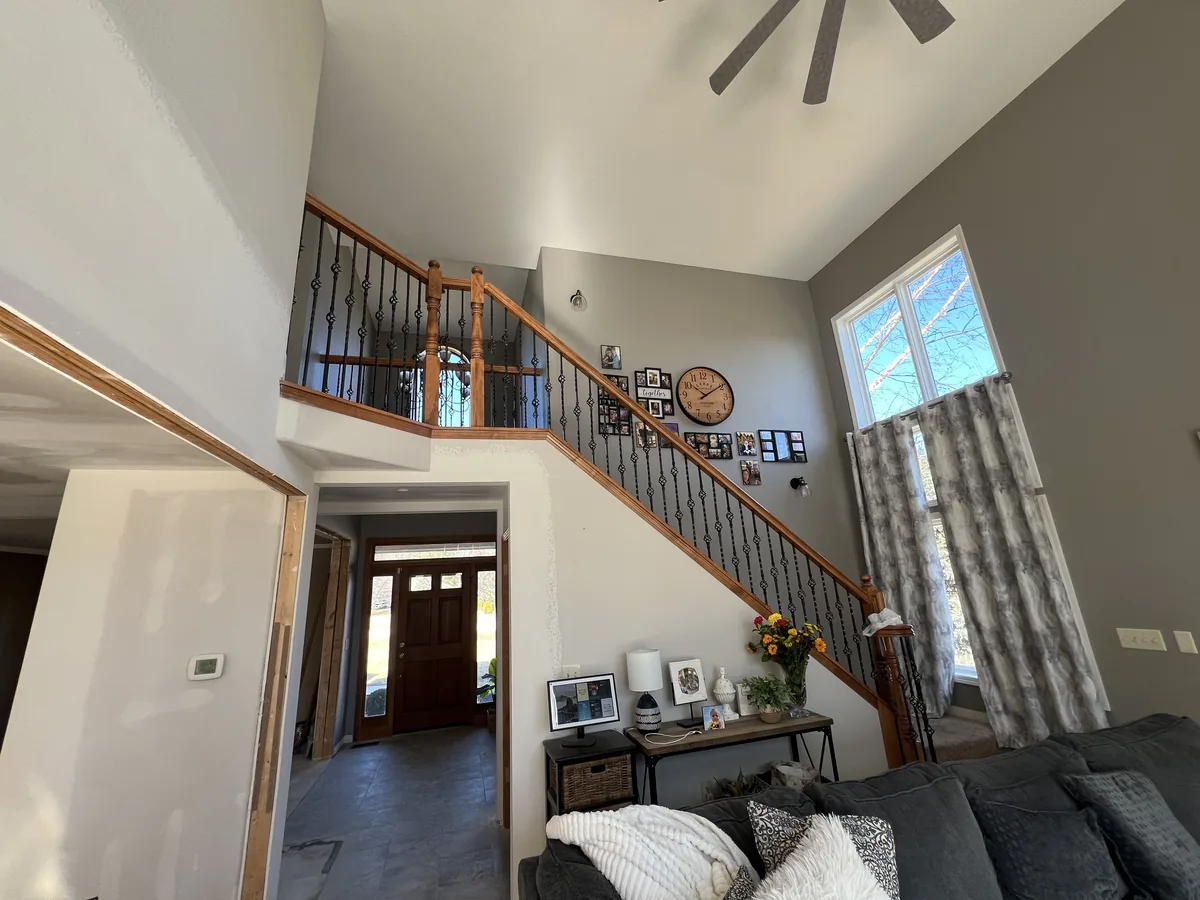 Two story entry staircase before the new black railing was installed